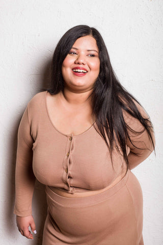 Detail shot of beige crop top’s high-low hem for a modern finish.