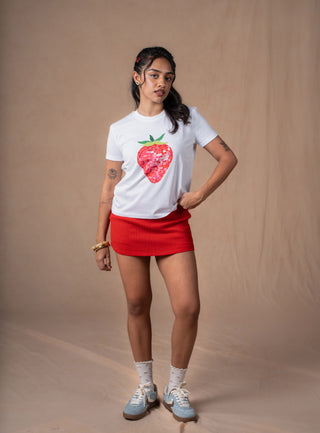 Model wearing white Strawberry tee with vibrant disco-inspired strawberry graphic print