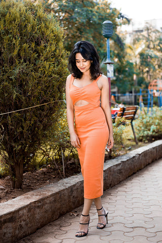 Side profile of the Tangerine Cut-Out Midi Dress, showcasing its fitted silhouette.
