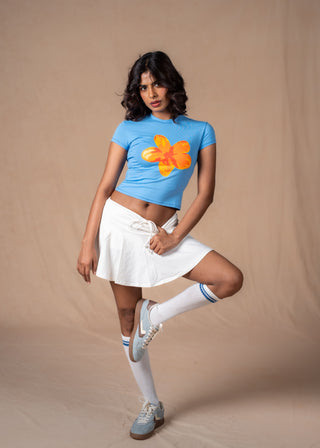 Model wearing the blue Sunset Tee with a sunset-hues floral graphic print